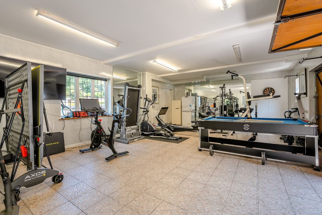 A gym and games room with a pool table