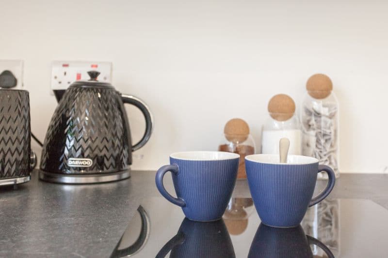 A kettle and mugs ready in the kitchen