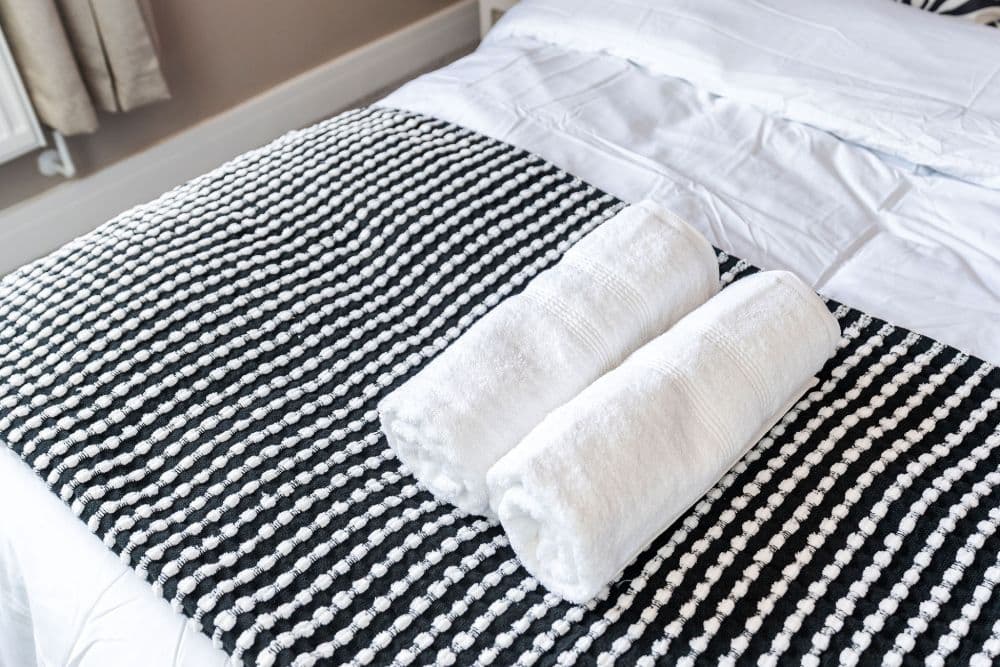 Fresh towels on a made bed